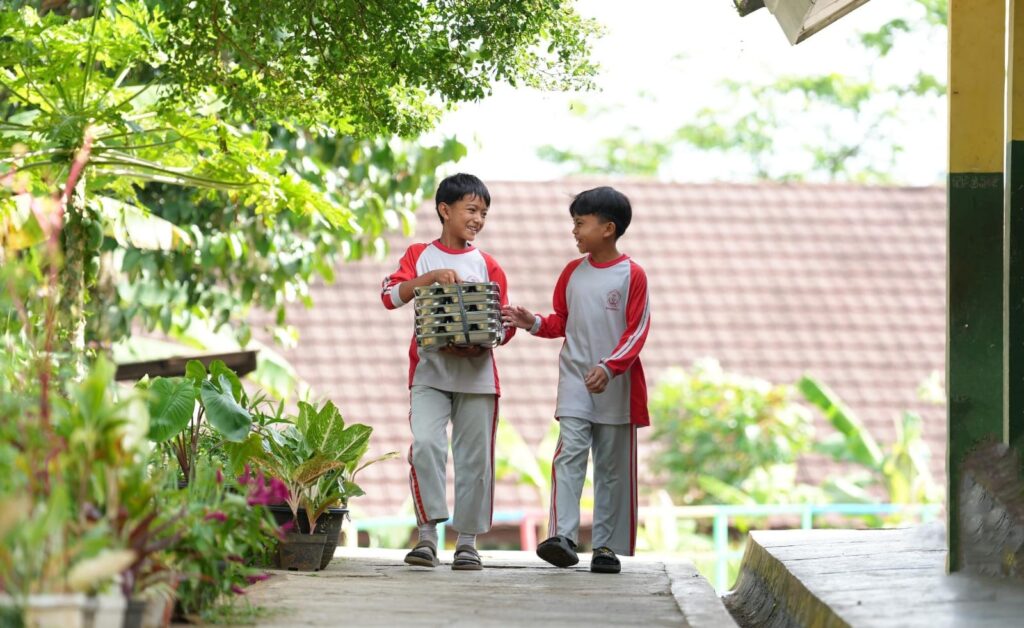Siswa di salah satu SDN Pancawati saat membawa nasi MBG